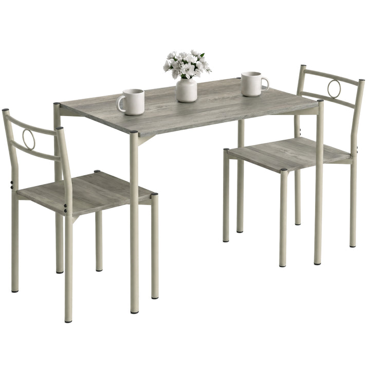 [Wooden Grey] Angled studio view of the three-piece dining set with two chairs, circular backs, mugs and a flower vase
