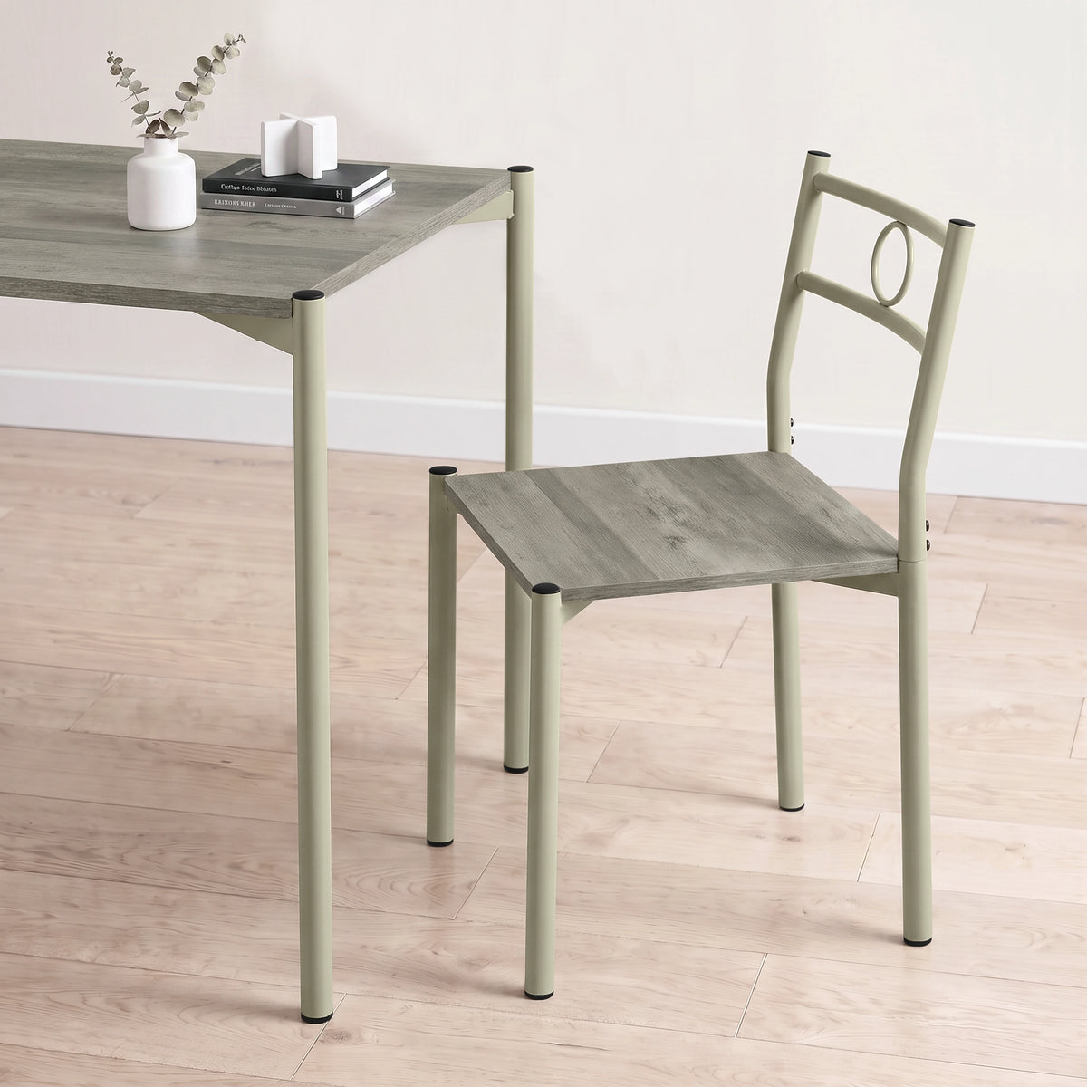 [Wooden Grey] Close-up showing the tabletop edge, chair seat, pale round-pipe legs, circular chair back, vase and books
