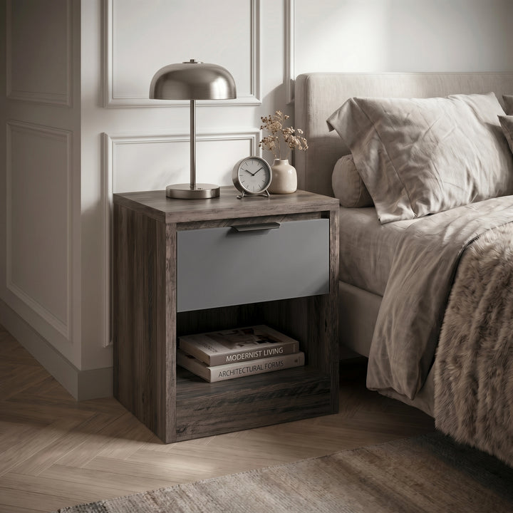 [Wooden Grey+Grey] Skova bedside table in bedroom setting showing textured wood frame, grey drawer and lower shelf