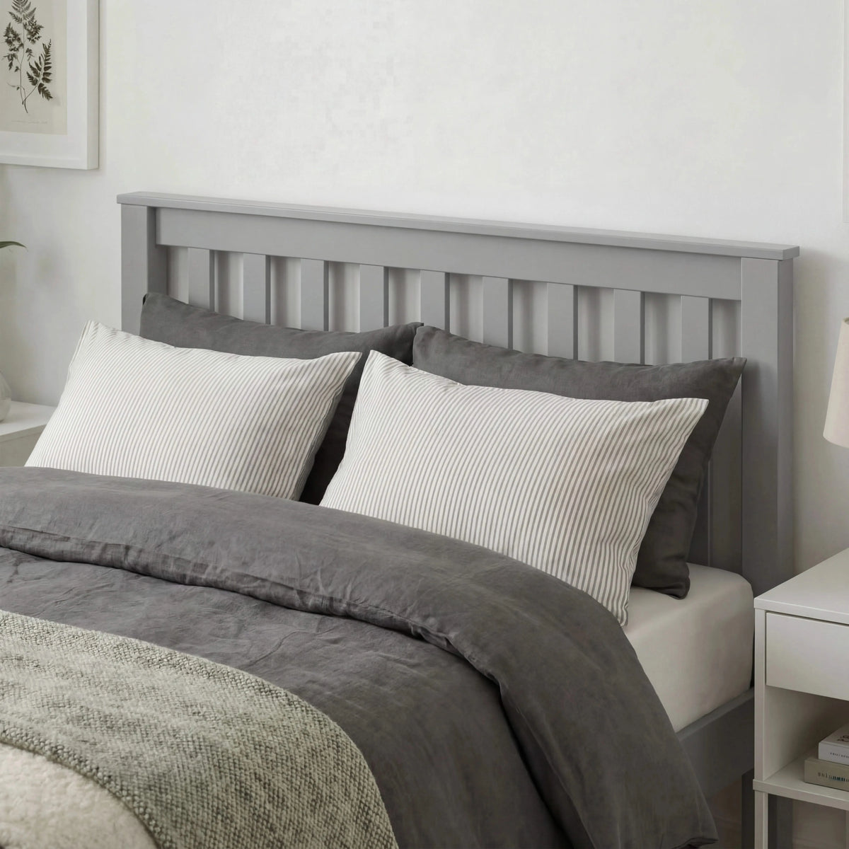 [Single | Grey] Close-up of grey wooden single bed headboard with slats above two pillows and grey duvet