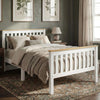 [Single | White + Pine] wooden twin bed frame with light natural wood headboard and footboard rails, styled in a bedroom with beige bedding, a nightstand, lamp, framed botanical prints, and a patterned rug.
